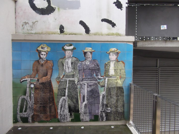 Four frocked up cyclists tiled wall art