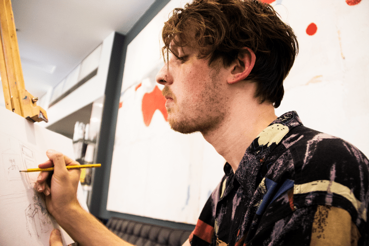 Artist Brendan Hartnett at Rakis on Collins painting event artist at work