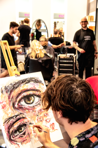 Artist Brendan Hartnett at Rakis on Collins painting event easel front